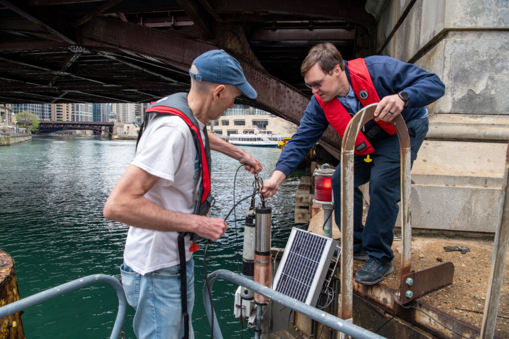 Current and MWRD staff installing an H2NOW sonde in the Chicago River